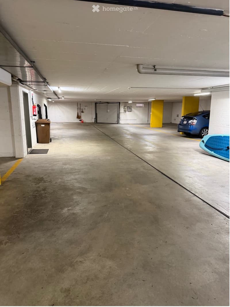 {"visible_features": ["Garage"], "type": "Garage", "objects": [], "description": "Underground parking garage with concrete floors, white walls, and a few parked vehicles including a blue car and a kayak.", "localized_descriptions": {"EN": "Underground par