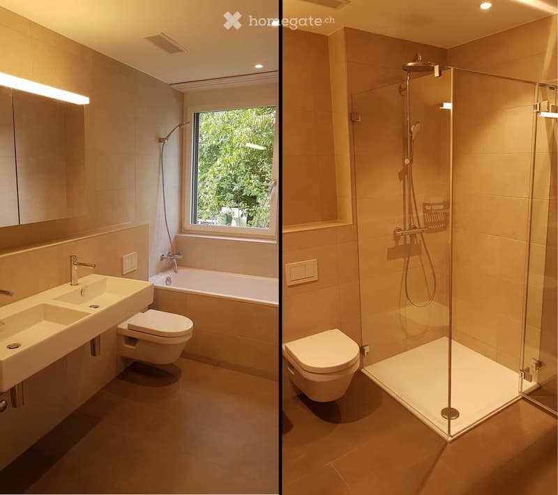 Modern bathroom with a double sink, toilet, bathtub, and separate glass-enclosed shower. Features large windows with a view of greenery.
