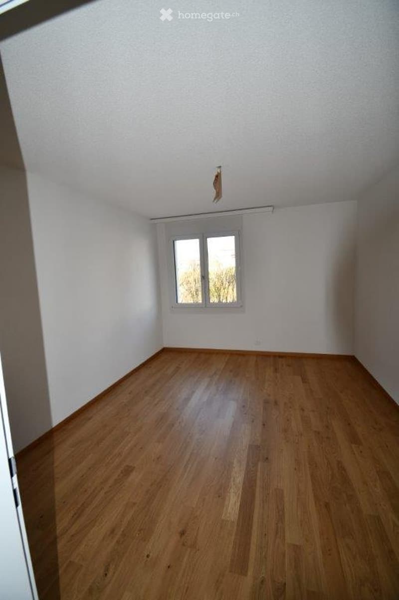 Completely empty room with bare white walls and wooden floor. No furniture or equipment.