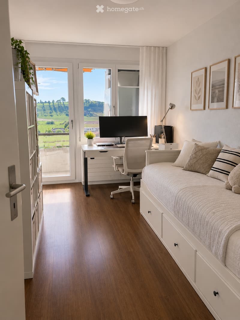 A modern bedroom with a daybed, desk, and large windows offering a scenic view. The room features a wooden floor, white walls, and framed artwork.