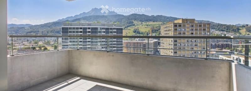 Balcony with a panoramic view of a cityscape and mountains, featuring a metal railing and tiled floor.