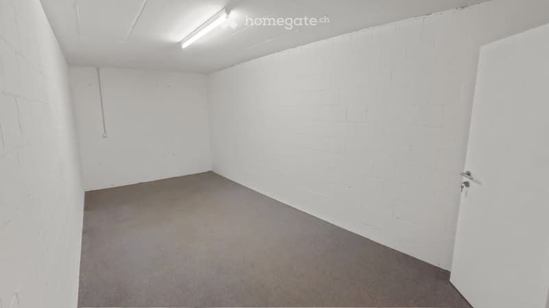 Empty room with white brick walls, concrete floor, and a single door.