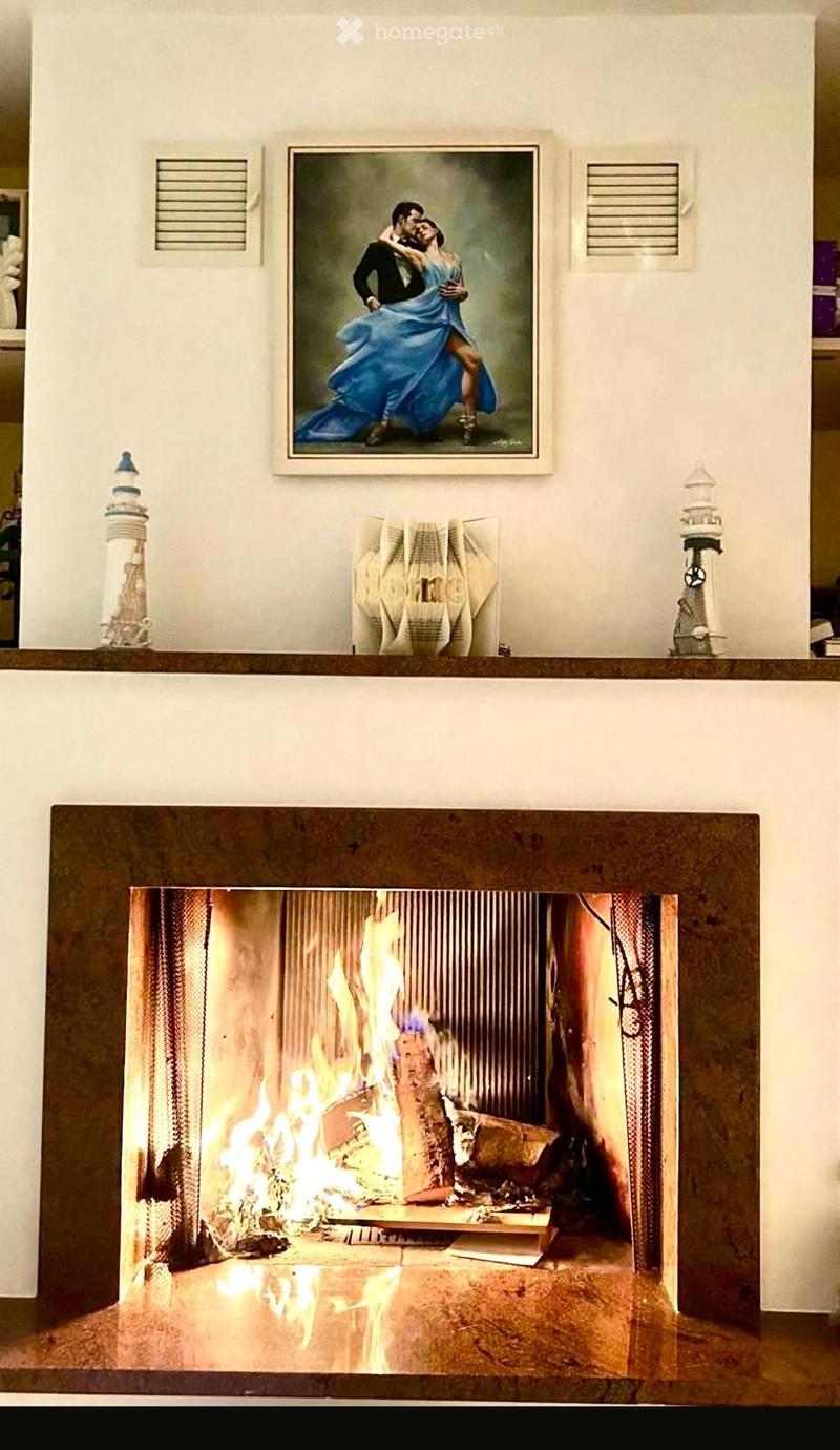 {"type": "Fireplace", "objects": ["picture frame", "lighthouse", "lighthouse", "home sign"], "visible_features": ["Fireplace"], "description": "A fireplace with a decorative mantel, featuring a framed picture of a dancing couple above it, two small lighth
