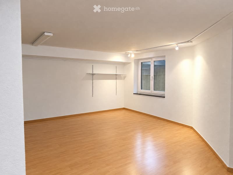 Empty room with wooden flooring, white walls, built-in closet with shelves, and a window with frosted glass panels.
