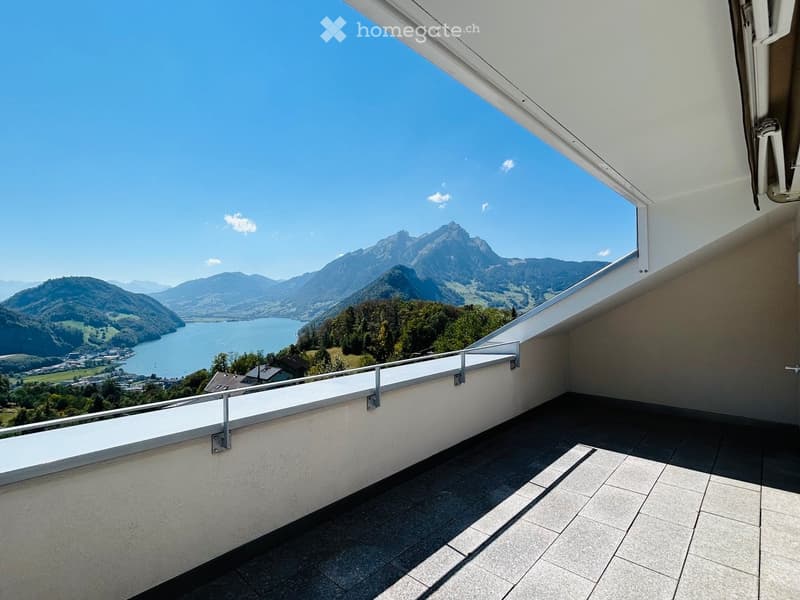Balcony with tiled floor, white railing, and scenic mountain and lake view.