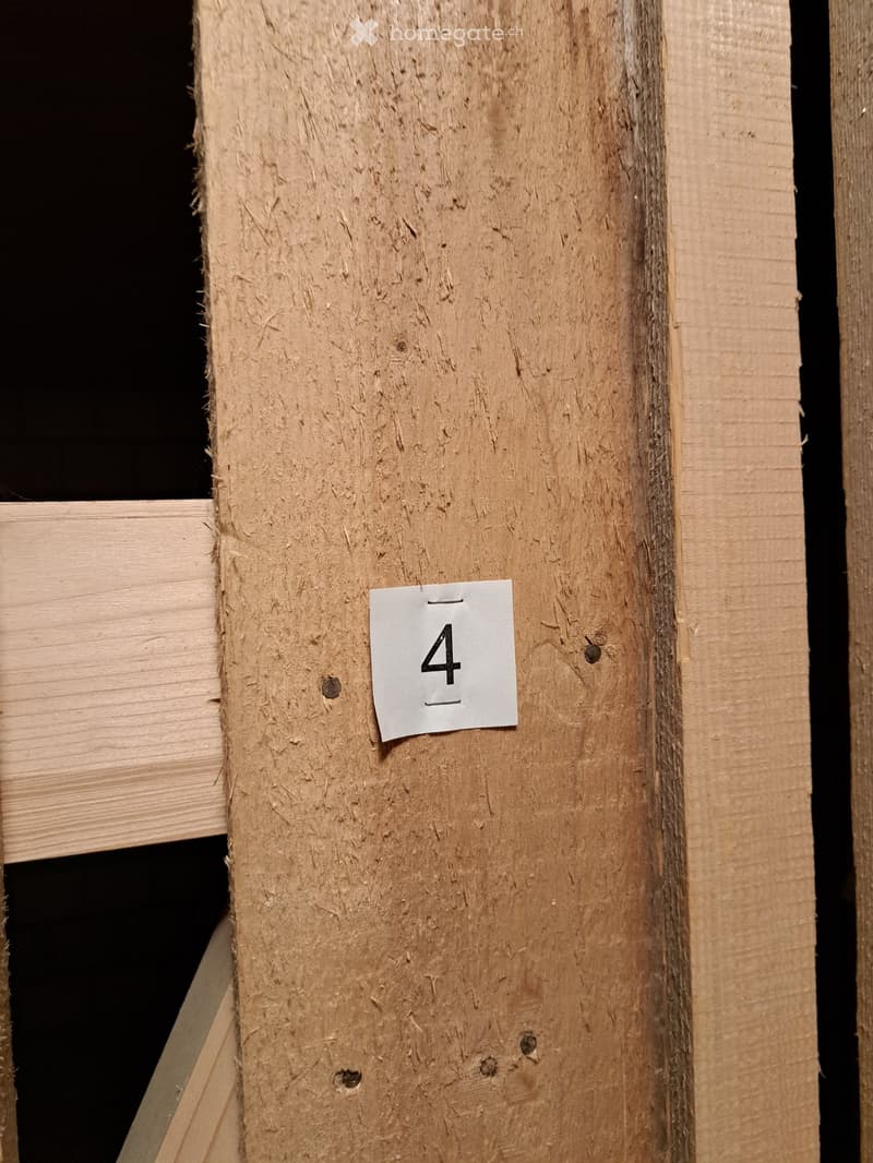 A close-up view of a wooden plank with a number "4" sticker attached to it, likely indicating a measurement or identification mark on a construction or assembly plan.