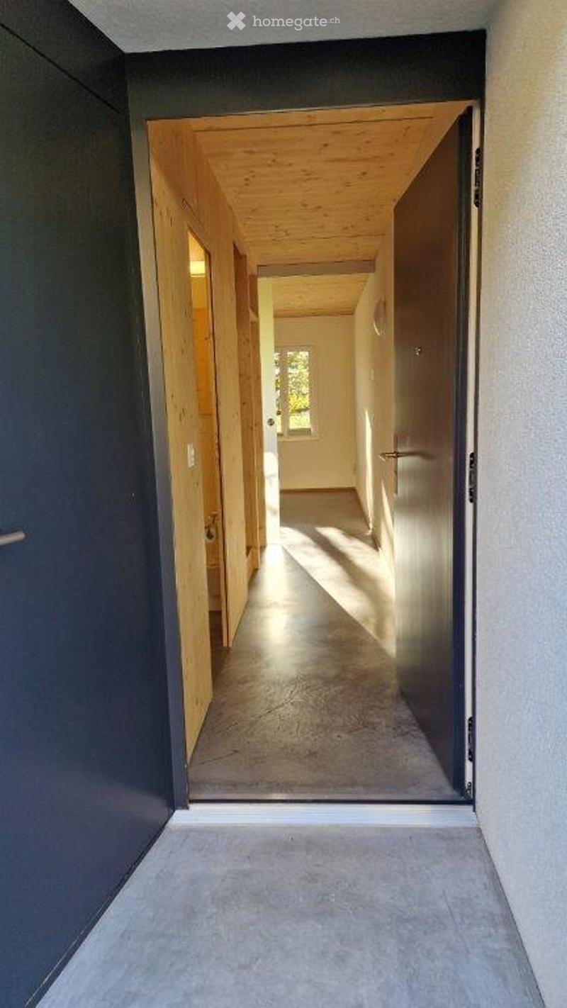 Modern hallway with wooden ceiling, tiled floor, and open doorways leading to other rooms.