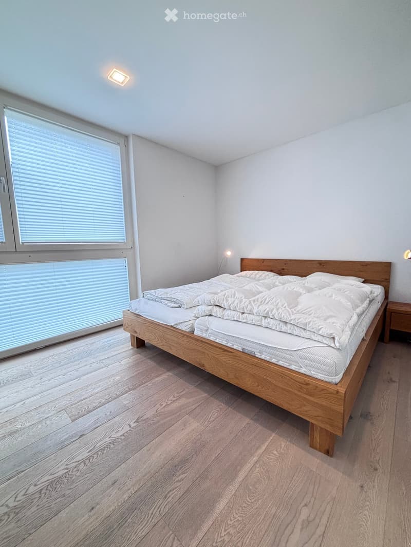 modern bedroom with a wooden bed, large window with blinds, wooden floors, bedside tables