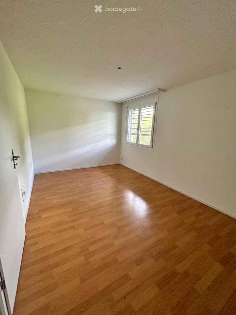 Empty room with wooden flooring, white walls, and a single window with blinds. No furniture or equipment present.