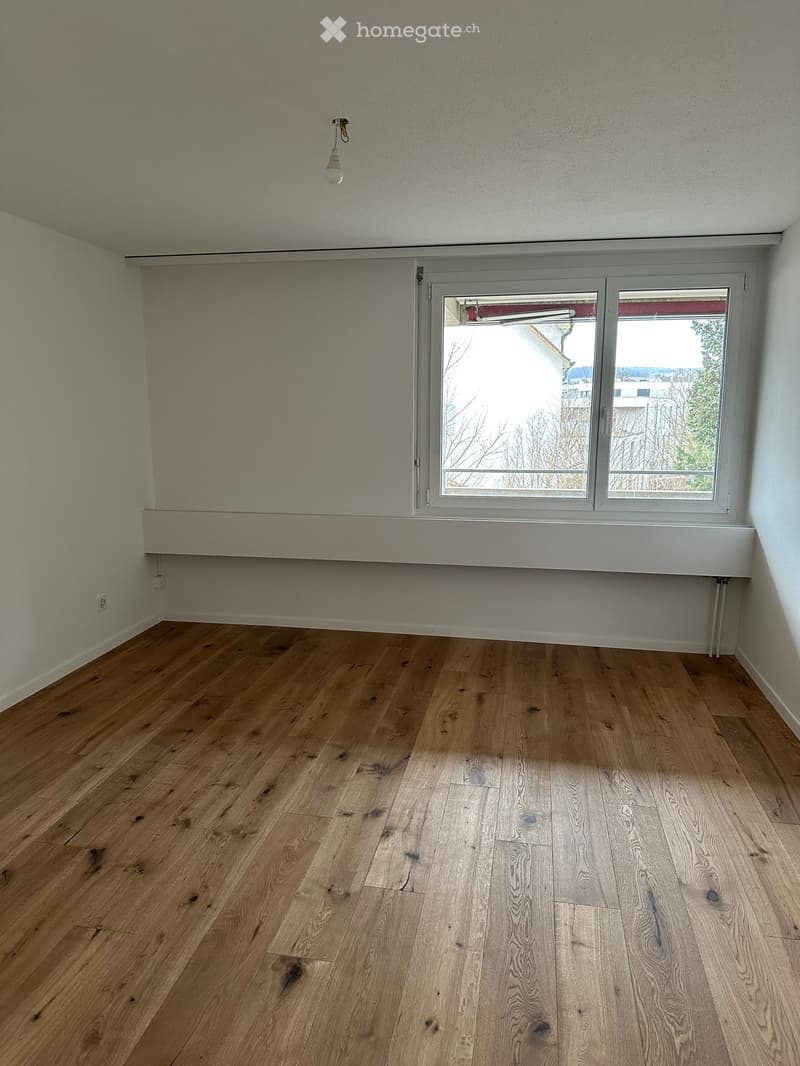 empty room with large window and wooden floor