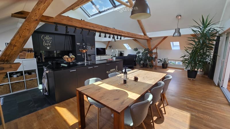 {"type": "Furnished Room", "objects": ["kitchen island", "dining table", "chairs", "sofa", "pendant lights", "wine bottle", "wine glasses", "kitchen cabinets", "kitchen sink", "faucet", "kitchen counter", "kitchen appliances", "kitchen utensils", "kitchen