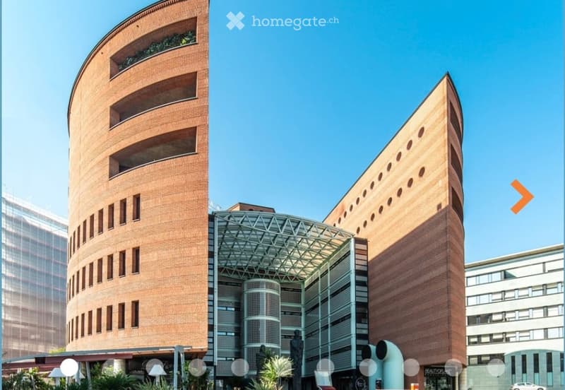 Modern building with curved brick facades, glass entrance, and geometric design.