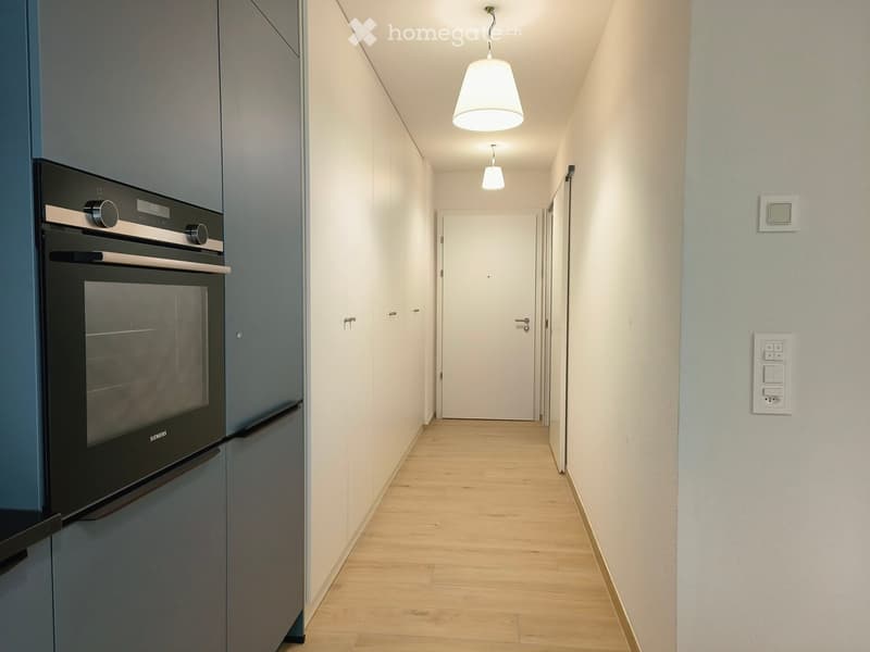 kitchen with built-in oven, large window, wooden floor, cabinets