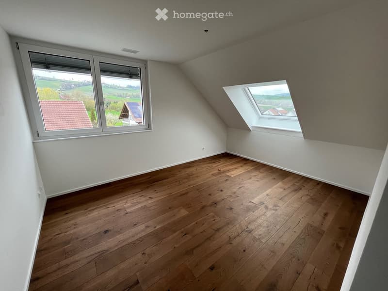 spacious empty room, wooden floors, white walls, two windows, valley view