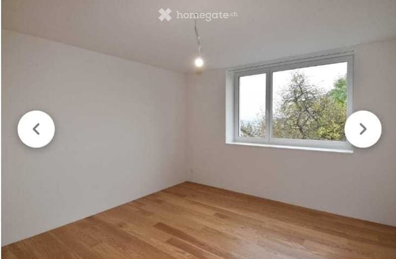 Empty room with light-colored walls, wooden flooring, and a single window with white frame. No furniture or equipment present.