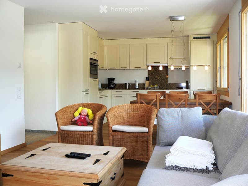 Open-plan living and dining area with fully equipped kitchen, sofa, coffee table, 2 armchairs, dining table, and chairs.