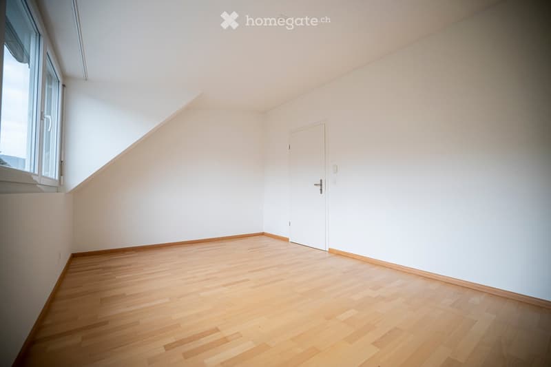 Completely empty room with bare white walls and light wooden flooring. No furniture or equipment.