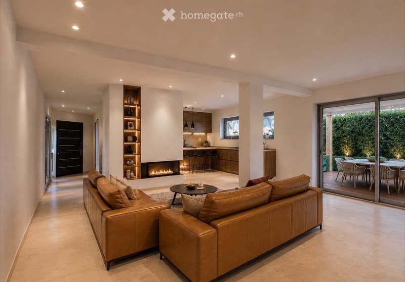 Modern living room with a large leather sofa, coffee table, fireplace, and open kitchen area with bar stools and a kitchen island. Shelves with decorative items are visible, and there is a dining area with a table and chairs through a sliding glass door.