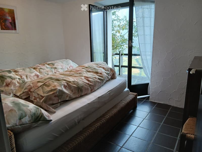 Two twin beds with floral comforters, French doors to balcony, tile floor