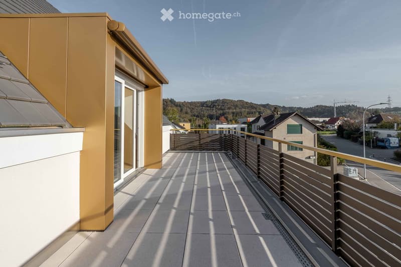 Modern balcony with tiled floor, metal railing, and a view of the surrounding neighborhood and hills.
