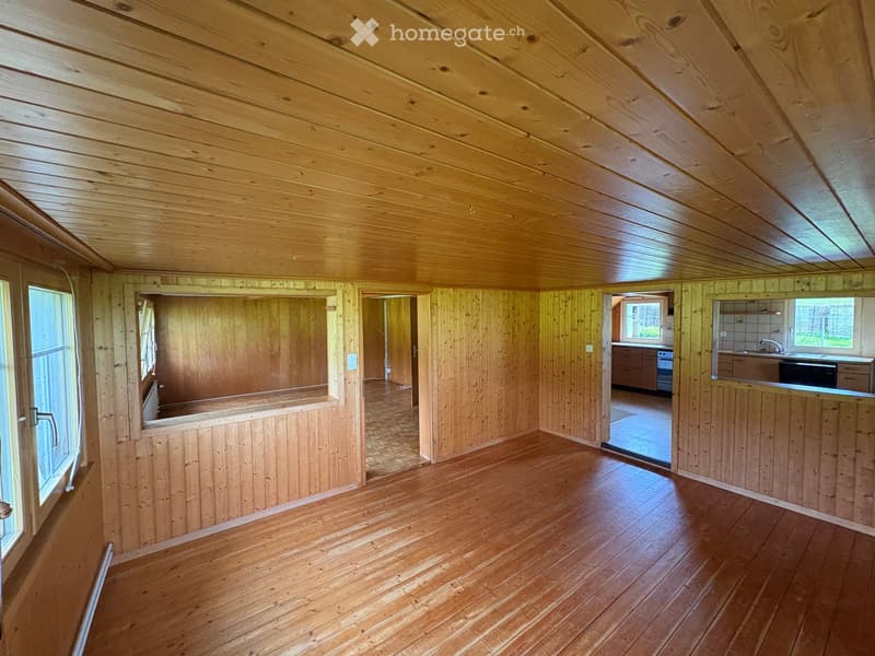 Empty room with wooden walls, wooden ceiling, and wooden floor. No furniture or equipment visible.