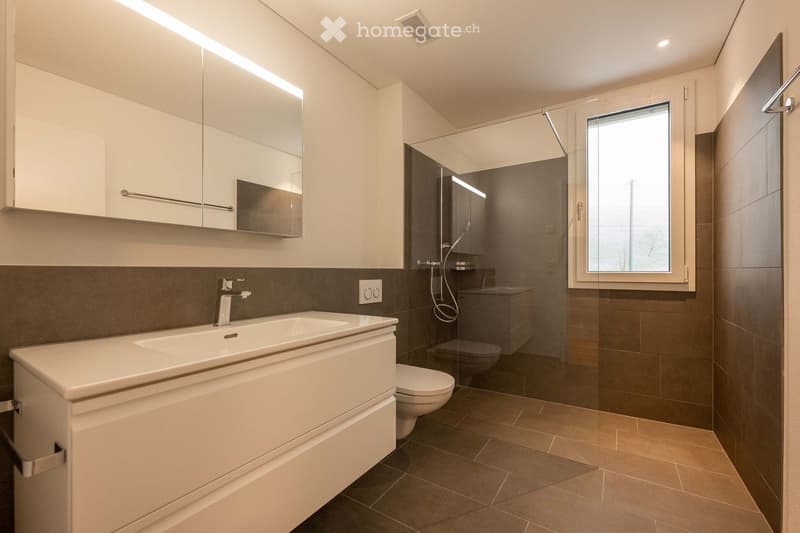 modern bathroom with white sink, mirror, toilet, shower, and tiled floor