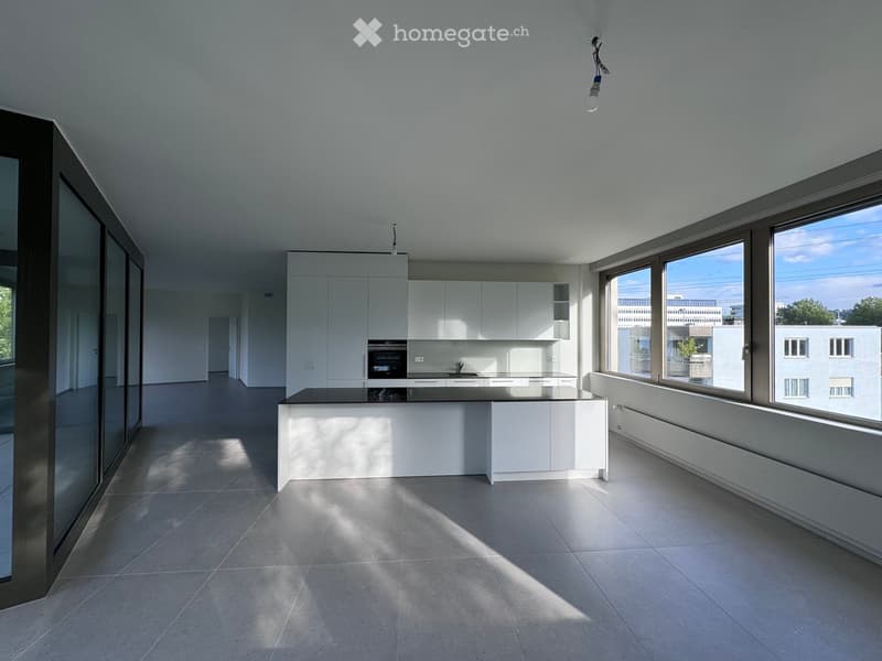 Modern kitchen with white cabinets, central island, and large windows overlooking the city.