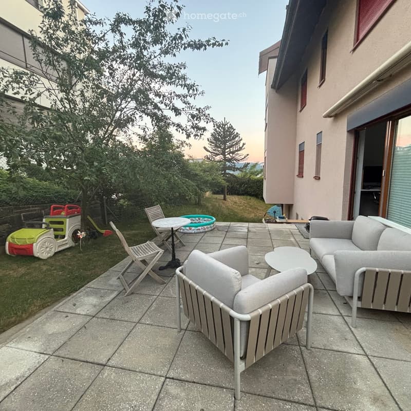 Garden area with patio furniture, including a sofa, chairs, and a table, along with a small inflatable pool and a toy car.