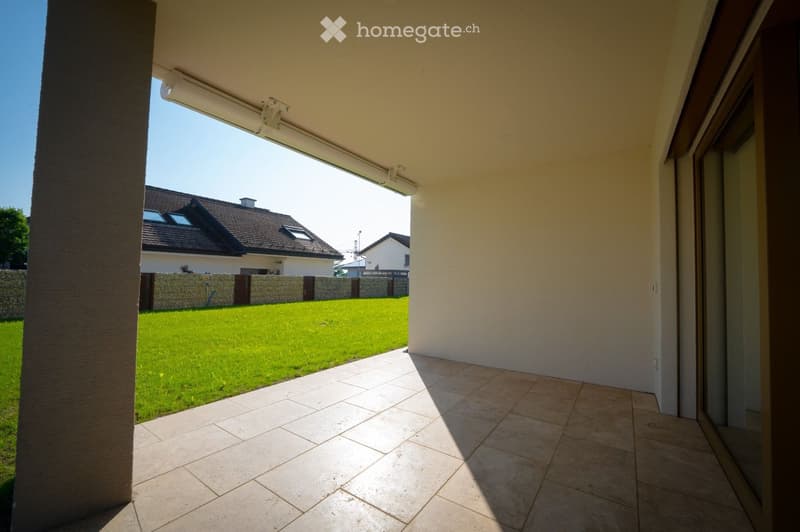 Balcony with tiled floor, open to a green lawn and neighboring houses.