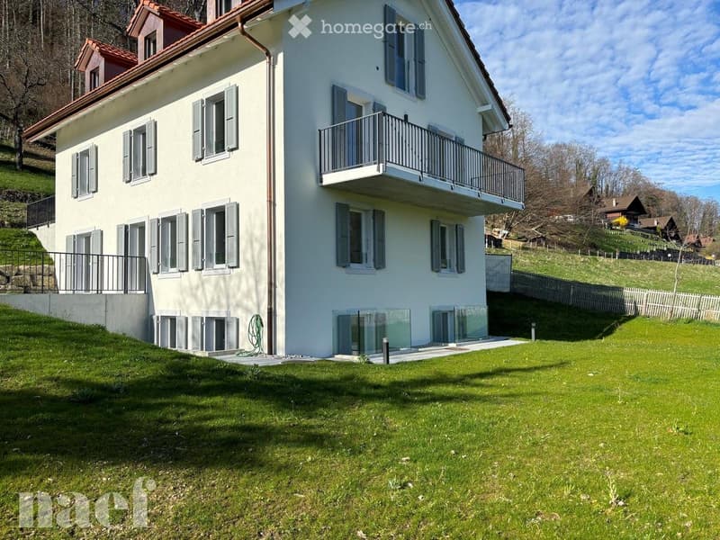 Two-story house with white exterior, multiple windows with shutters, balconies, and a well-maintained lawn.