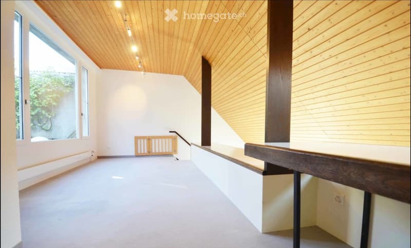 Modern, minimalist hallway with wooden ceiling, white walls, large windows, and a staircase leading upwards.