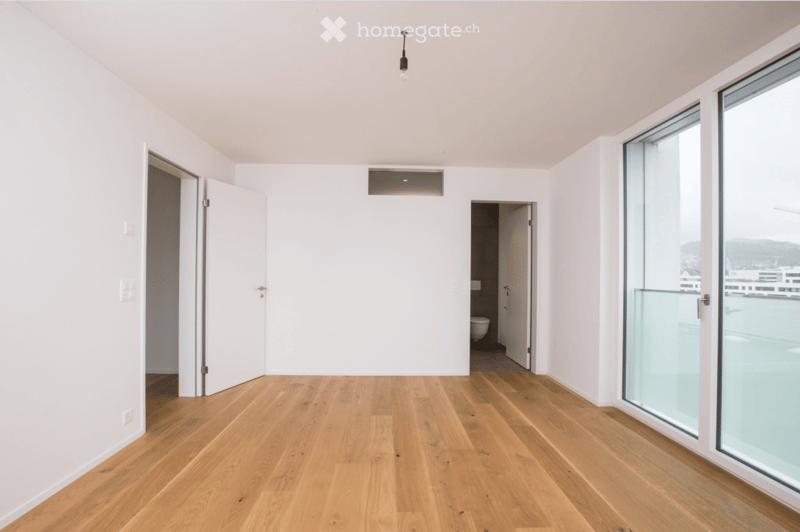 Completely empty room with bare white walls and wooden floor. No furniture or equipment.