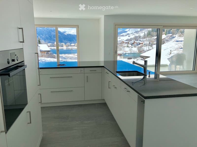 Kitchen. Modern kitchen with white cabinets, granite countertops, and a view of snowy mountains.