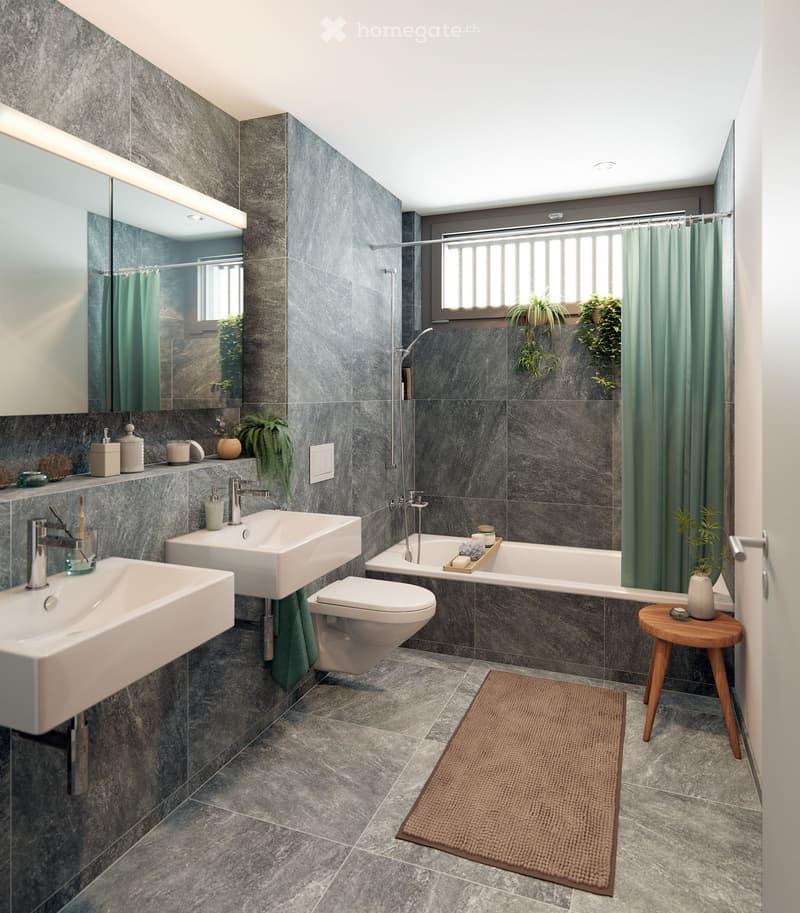 Modern bathroom with dark grey tiles, double sink vanity, bathtub, toilet, and a small wooden stool with a plant. Features a large mirror with built-in lighting and a window with green curtains.
