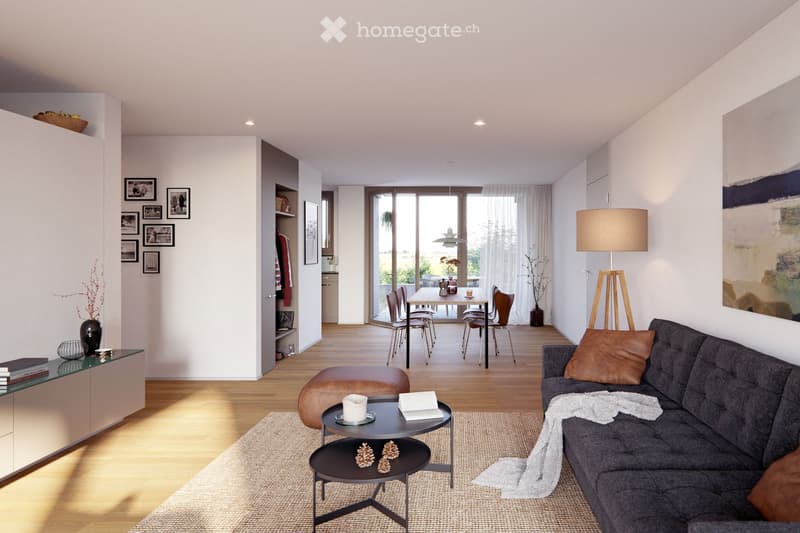 Modern living room with a grey sectional sofa, coffee table, ottoman, floor lamp, dining area with a table and chairs, and decorative items including picture frames and vases.