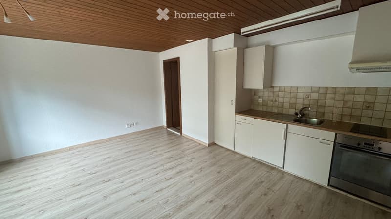 empty kitchen with sink, stove, cabinets, light switches, power outlet