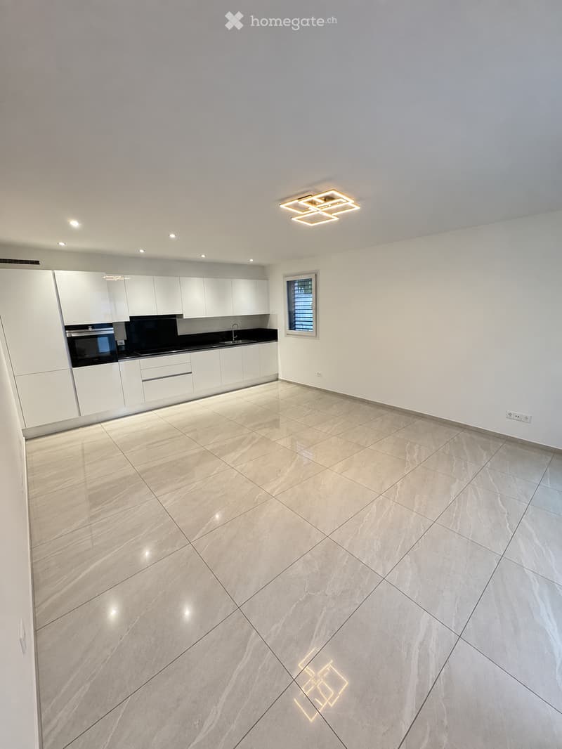 Modern kitchen with white cabinets, a built-in oven, and a sink, featuring a large window and recessed lighting.