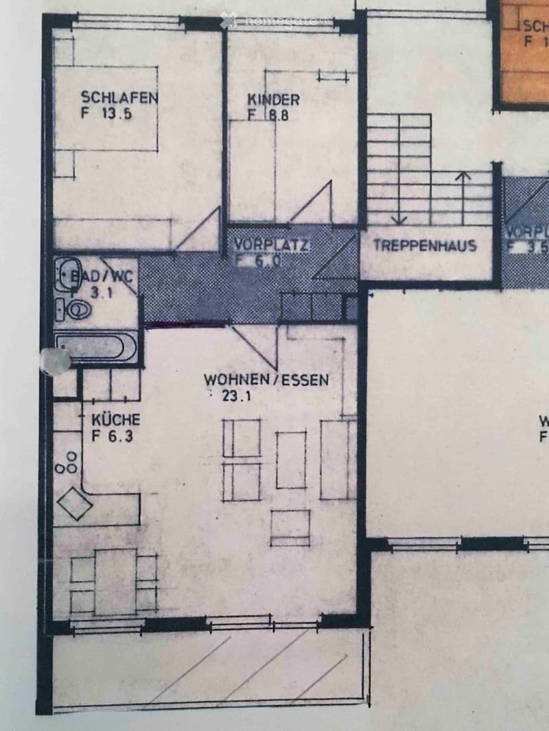 Floor plan showing a layout with labeled rooms: WOHNEN/ESSEN (23.1), KÜCHE (6.3), BAD/WC (3.1), SCHLAFEN (13.5), KINDER (8.8), VORPLATZ (6.0), TREPPENHAUS, and SCHLAF F1.5.