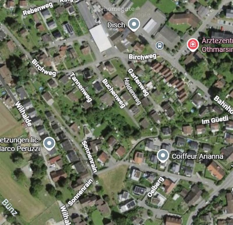 Aerial view of a residential area with multiple houses, streets, and labeled landmarks including Arztzentrum Othmarsirn and Coiffeur Arianna.