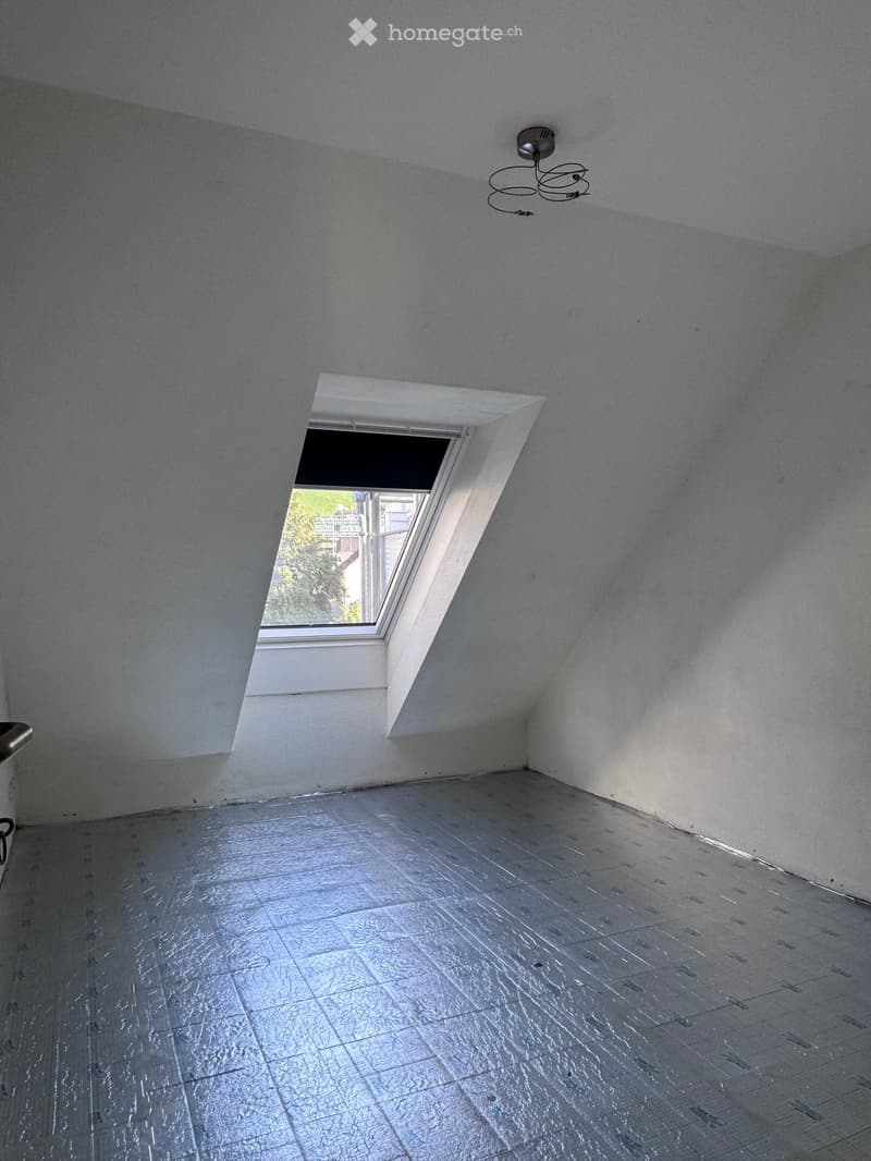 Empty room with bare walls, a skylight window, and a tiled floor. No furniture or equipment is present.