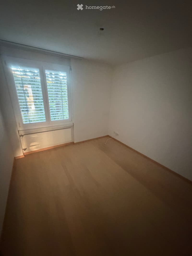 Empty room with wooden flooring, white walls, and a window with blinds. No furniture or equipment is present.