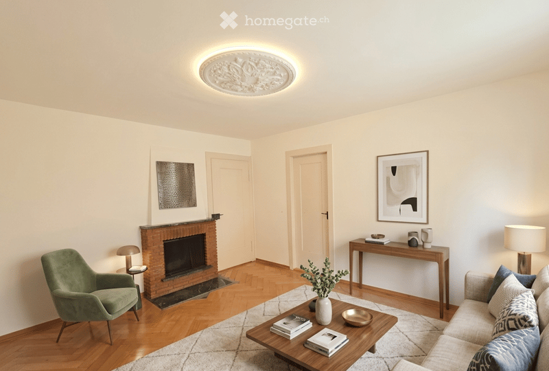 Modern living room with hardwood flooring, fireplace, sofa, coffee table, armchair, side table, and decorative items.