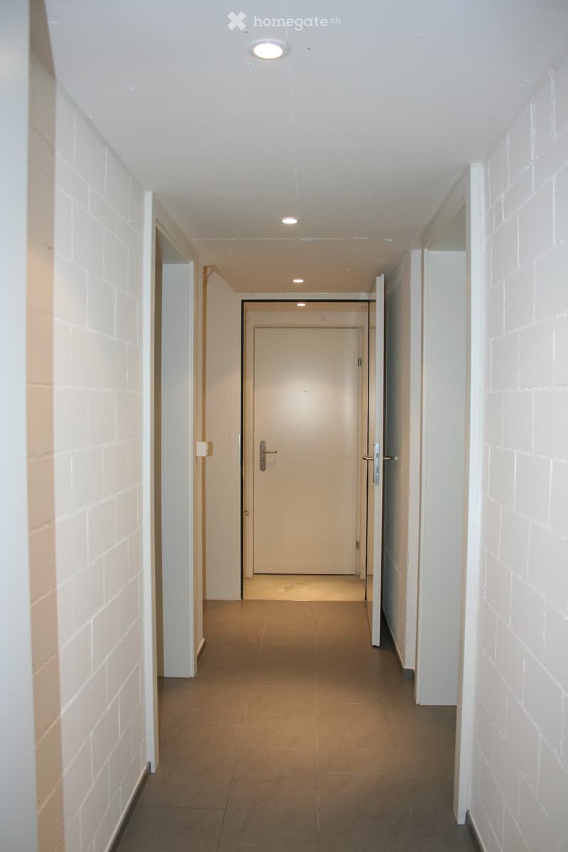 empty hallway, white walls, beige floor, open door