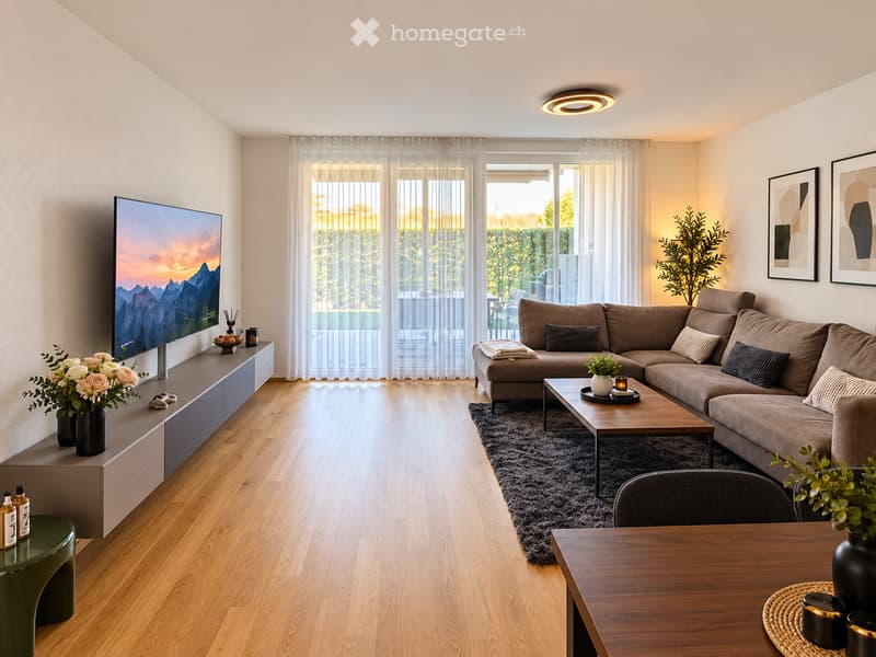 Modern living room with a large sectional sofa, coffee table, TV, and a dining area with a table and chairs. The room features wooden flooring, large windows with sheer curtains, and decorative elements like vases and artwork.