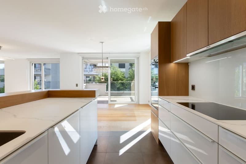 Modern kitchen with white and wood cabinets, marble countertops, and a large window leading to a balcony.