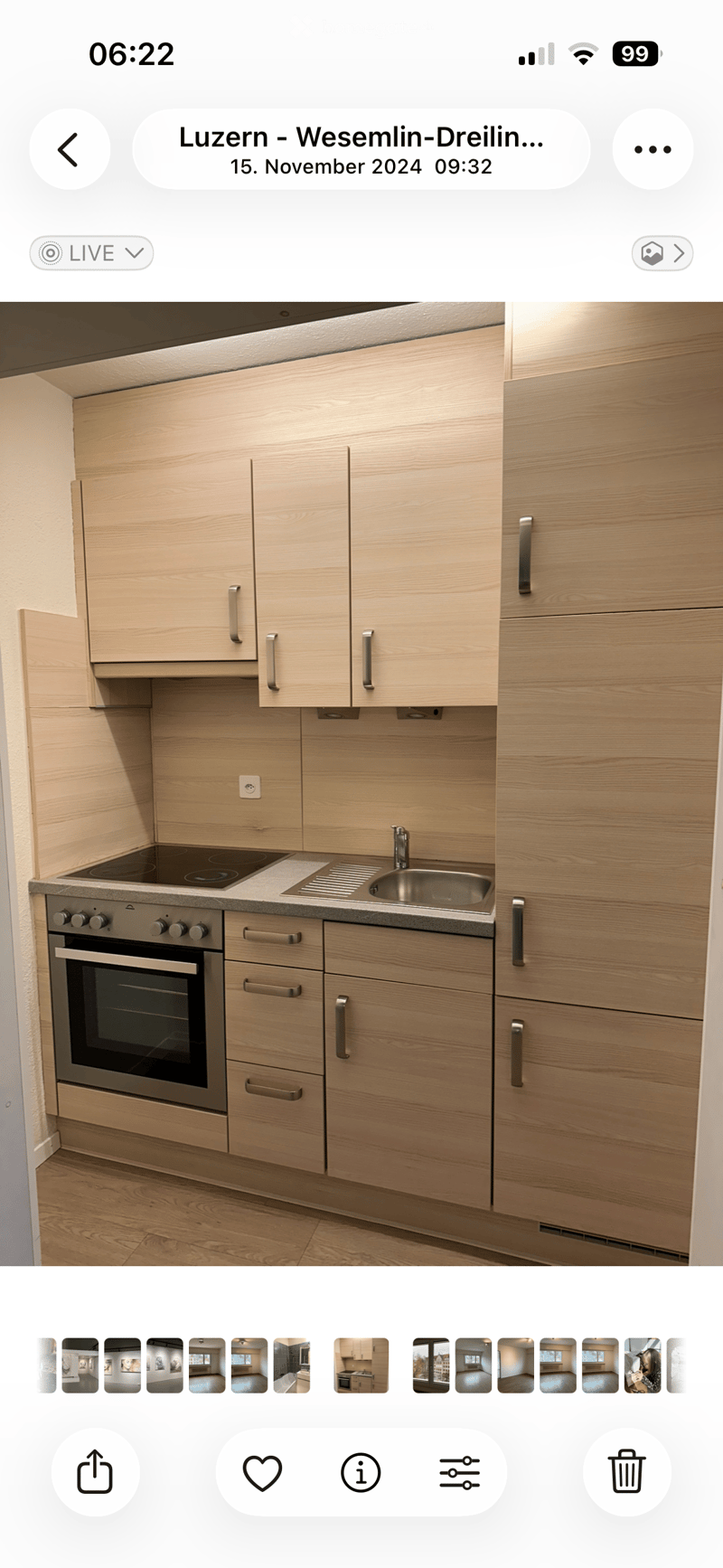 Modern kitchen with light wooden cabinets, stainless steel oven, sink, and faucet.