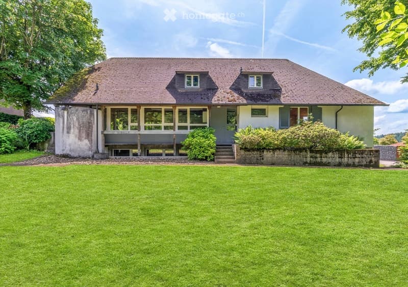 Detached house, brown roof, white walls, large windows, balcony, wide green lawn, trees
