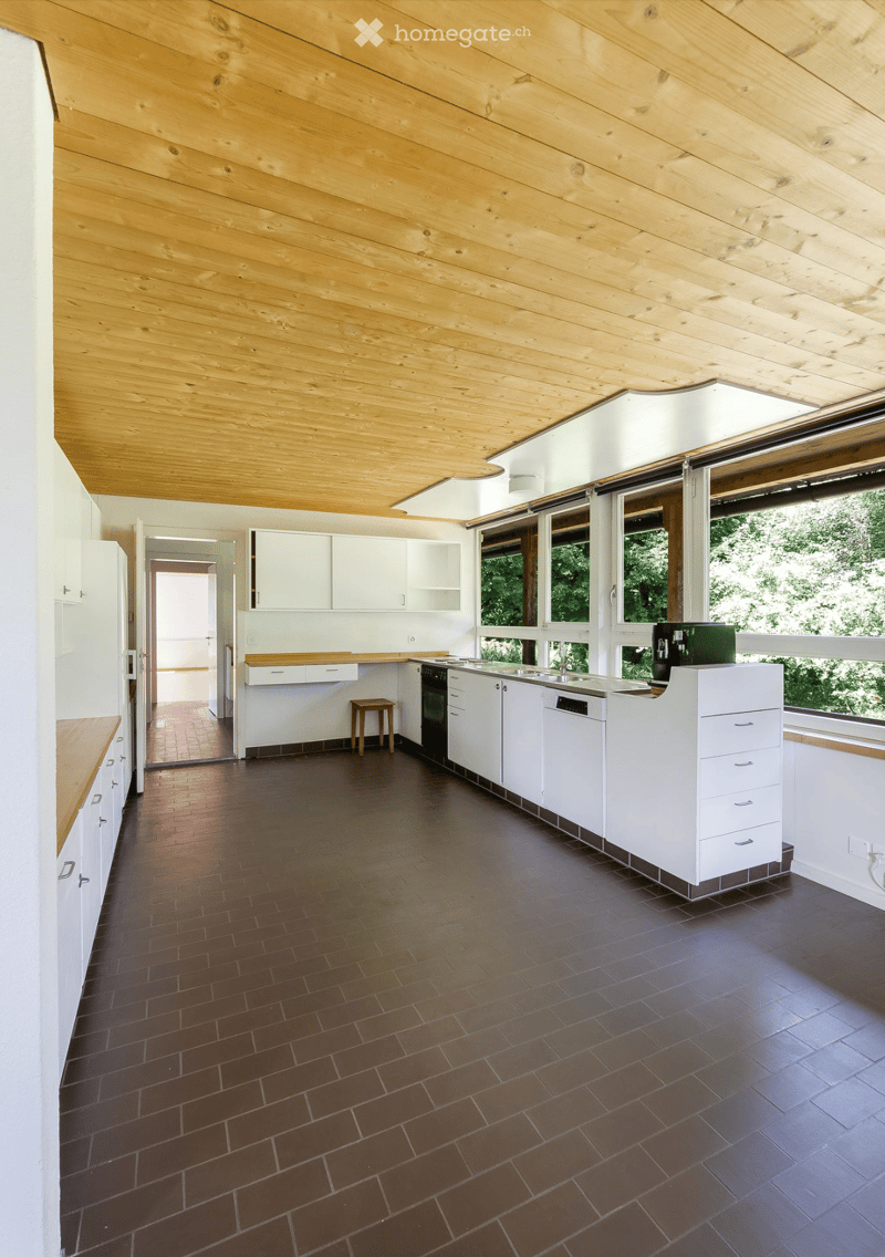 modern kitchen, white cabinets, tiled flooring, wooden ceiling, windows, large countertop, dishwasher