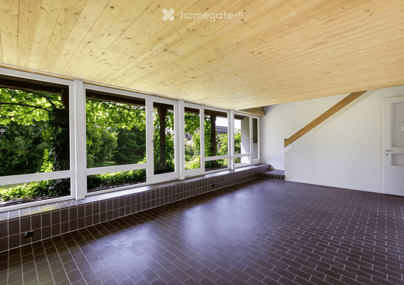 Empty room, wooden ceiling, large glass windows, black and grey tiled floor