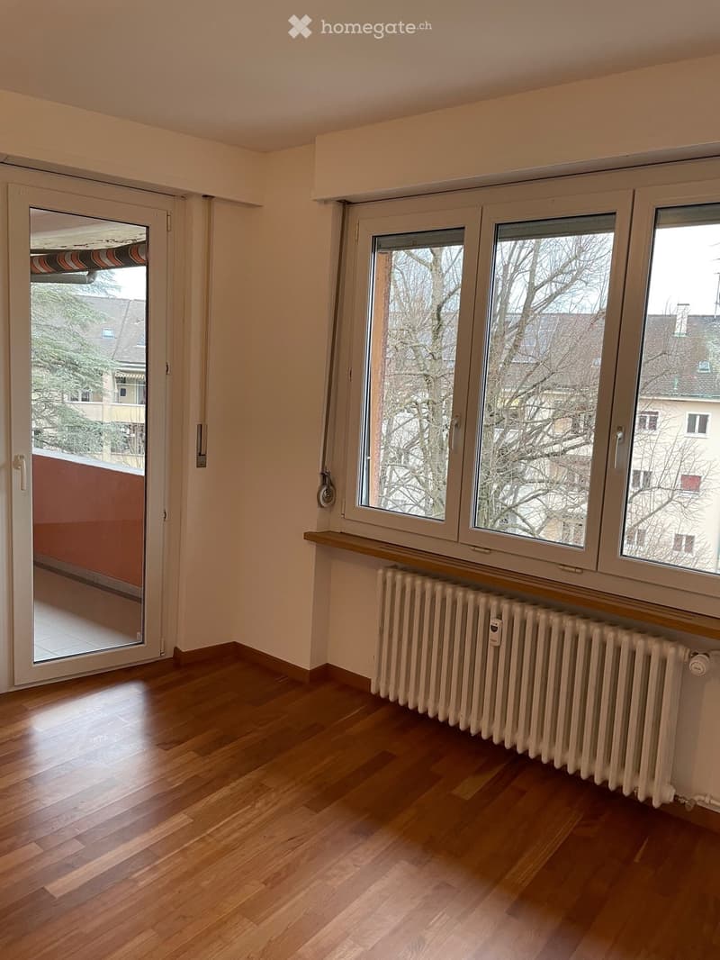 hardwood floors, sliding doors to balcony, windows, radiator, clear view of trees and buildings